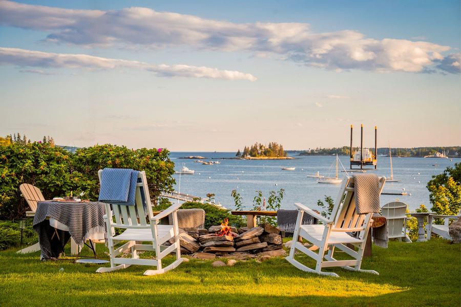 Adirondack chairs on a waterfront lawn overlooking Boothbay Harbor